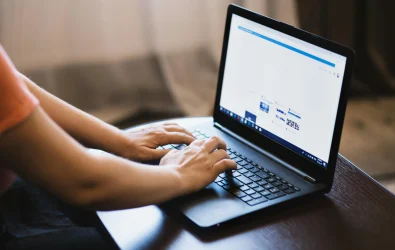 Personne utilisant un ordinateur portable pour naviguer sur Internet, potentiellement exposée au phishing.
